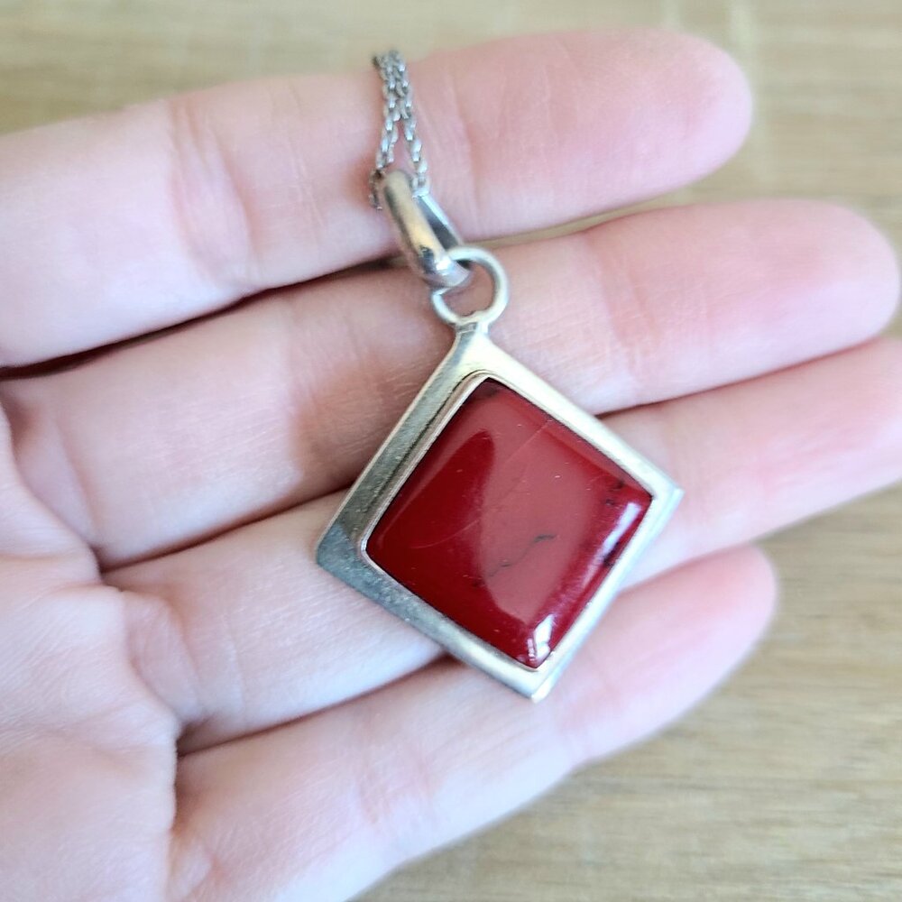 Sterling silver pendant on chain with red stone.